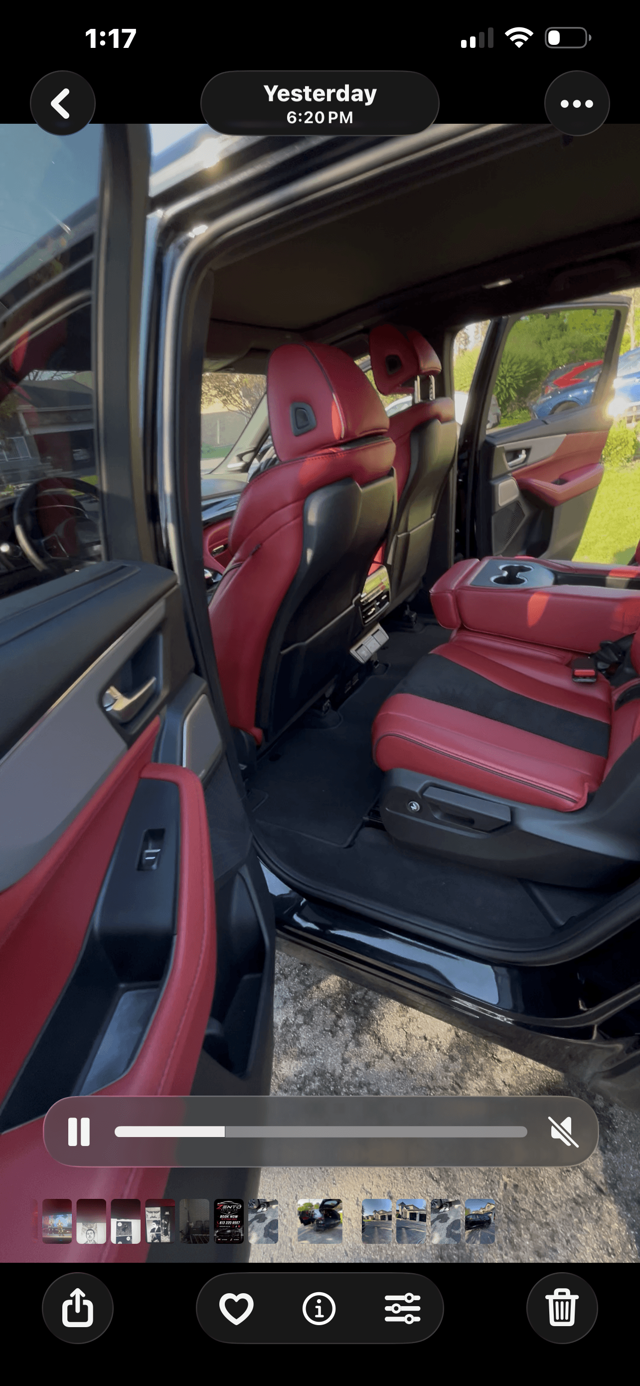 Modern car interior with red and black leather seats visible through an open rear door.